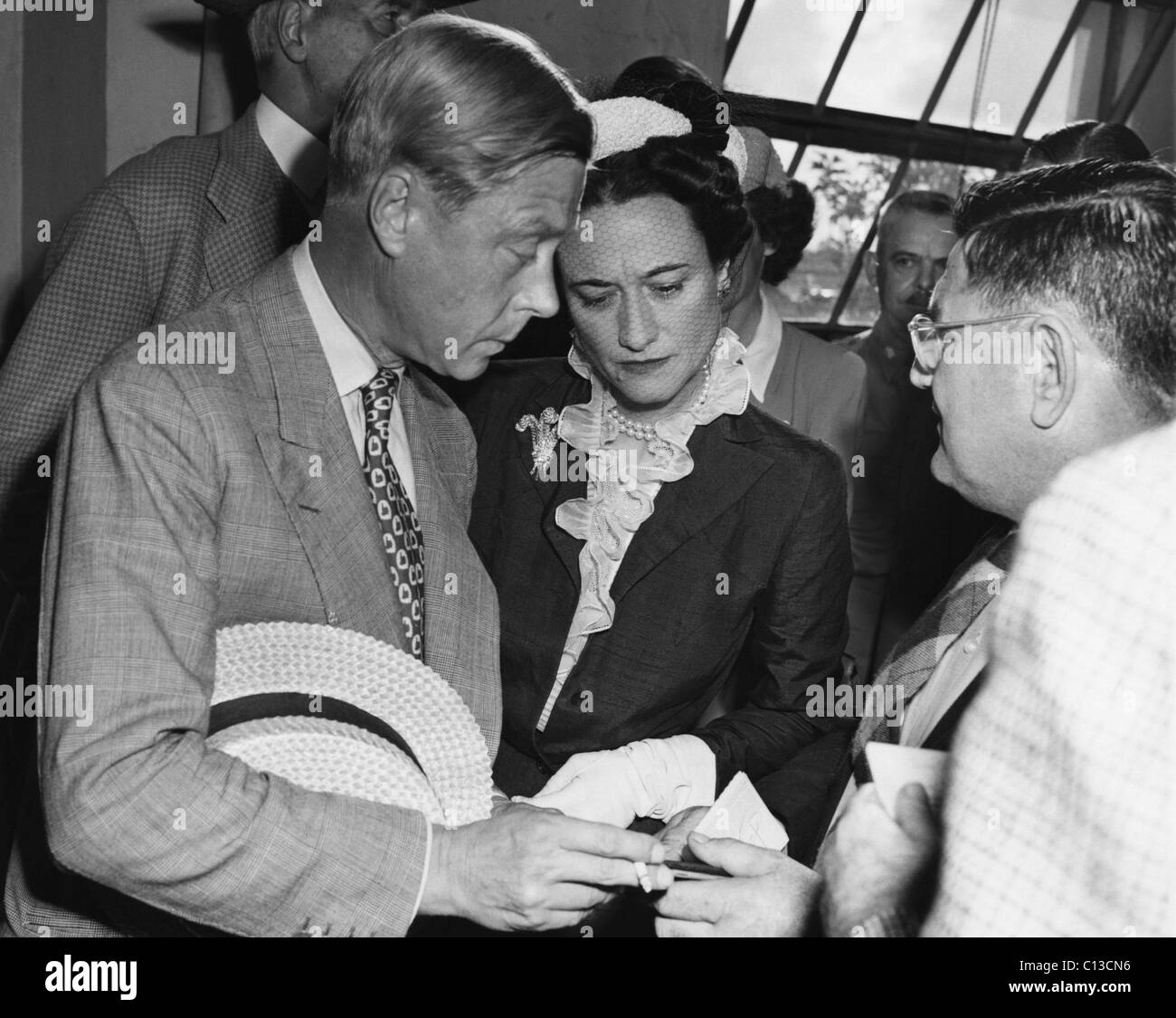 De gauche à droite : le prince Edward, duc de Windsor et de la Duchesse de Windsor, Wallis Simpson recevoir leur passeport à partir de la police de Miami le capitaine E.W. Melohen à son arrivée à Miami, Floride, 1942. Banque D'Images