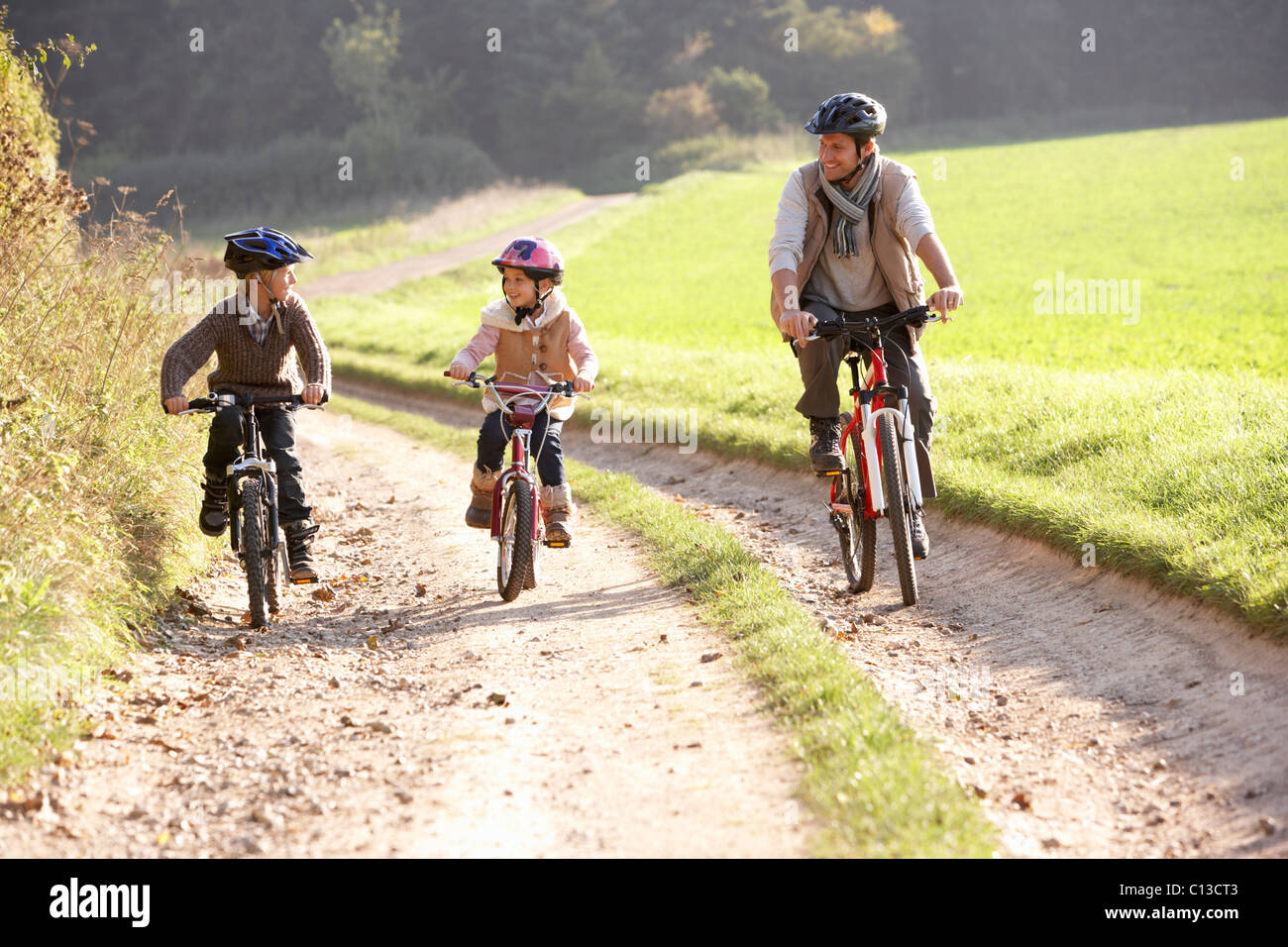 Jeune père avec les enfants faire du vélo dans la région de park Banque D'Images