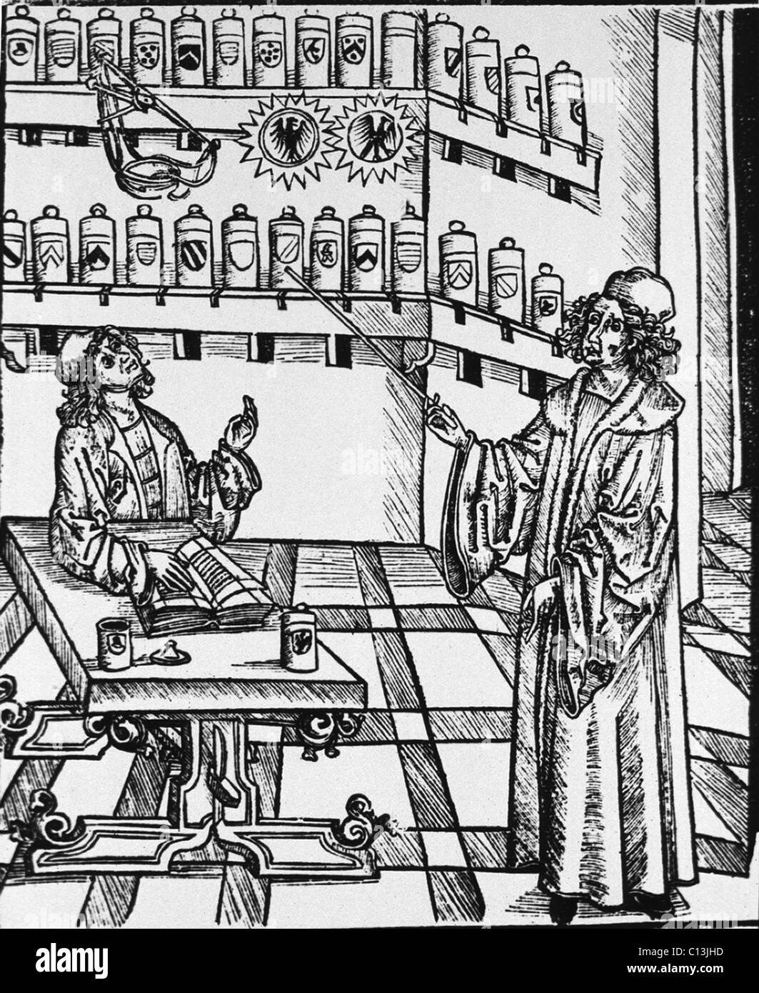 Une leçon pharmaceutique montrant le maître, en pointant sur des étagères de pots d'apothicaire, demandant à l'apprenti à une table avec un livre ouvert. Gravure sur bois d'MEDICINARIUS. DAS BUCH DER GESUNTHEIT (livre de la santé), par Hieronymus Brunschwig, ca. 1505. Banque D'Images