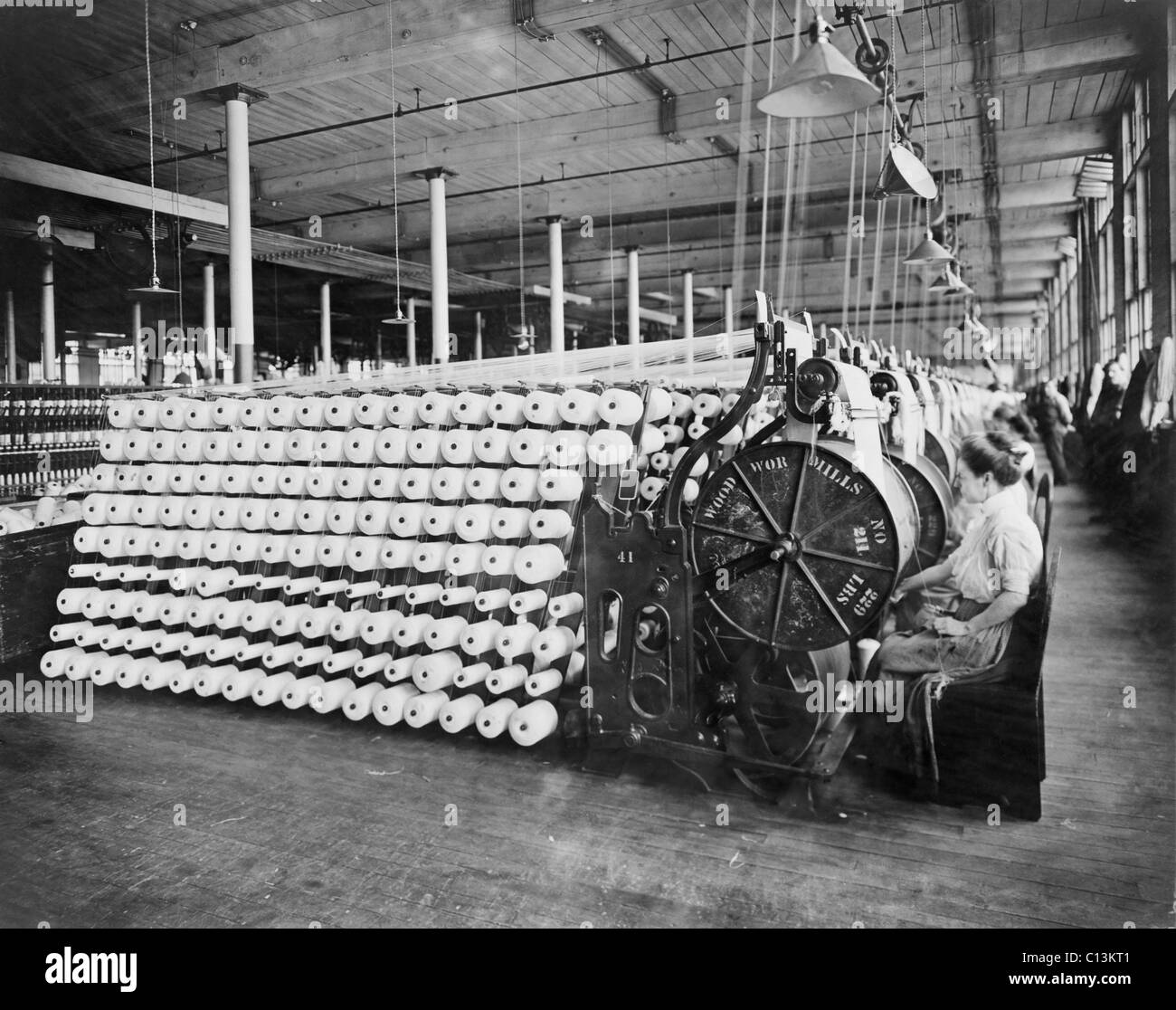 Les femmes travaillant à des machines textiles, la transmission et l'inspection des fils, à l'American Woolen Company, Boston. Le processus de transmission, la chaîne prépare les fibres de la longueur d'un tissu. Ca. 1910. Banque D'Images