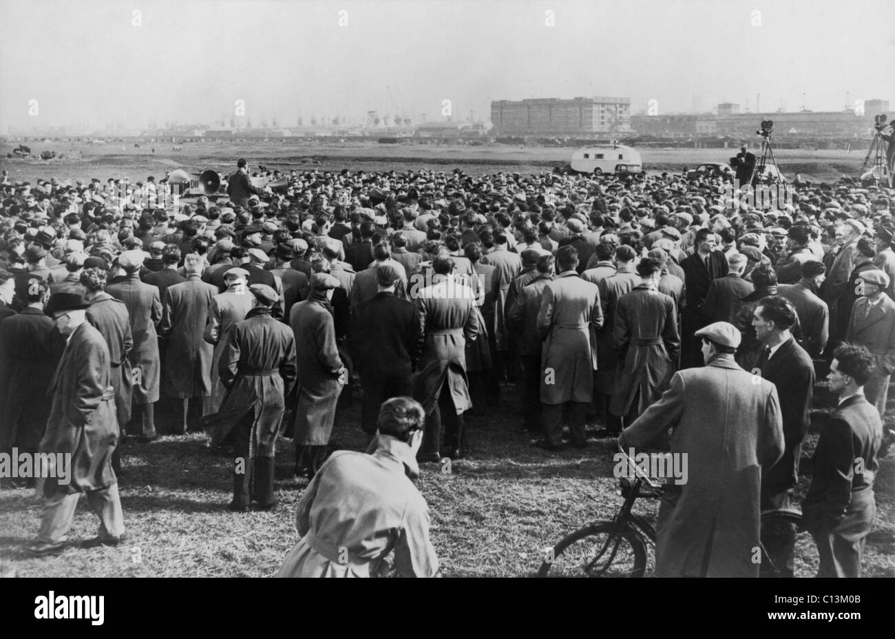 Foule de frapper les travailleurs de la réparation des navires à l'écoute des hommes avec des haut-parleurs au rassemblement au champs de Custom House, Londres, le 20 mars 1957. Banque D'Images