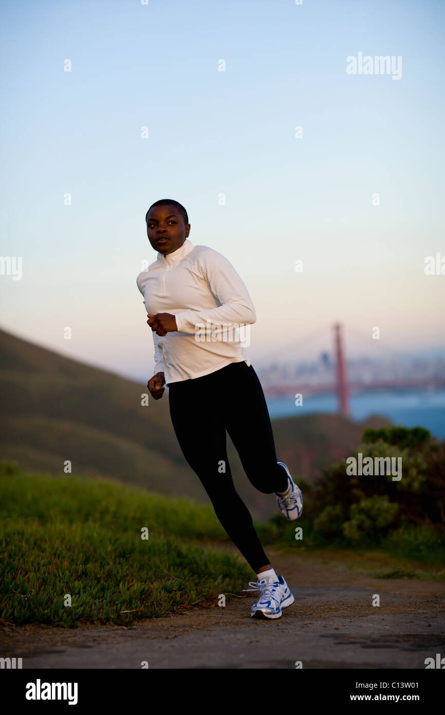 États-unis, Californie, San Francisco, Woman jogging, le Golden Gate Bridge en arrière-plan Banque D'Images