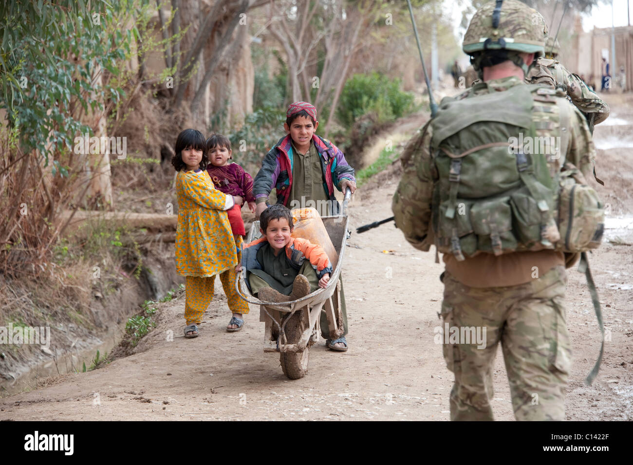 Les enfants de l'Helmand en Afghanistan des soldats salue Banque D'Images