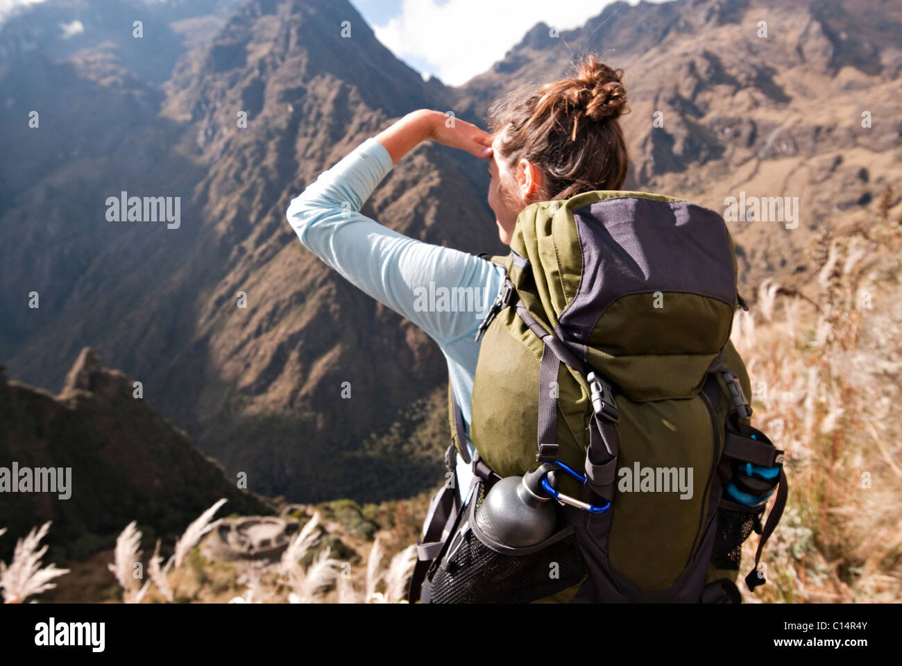 Une jeune femme cherche dans la distance sur d'anciennes ruines Incas le long du chemin de l'Inca. Banque D'Images