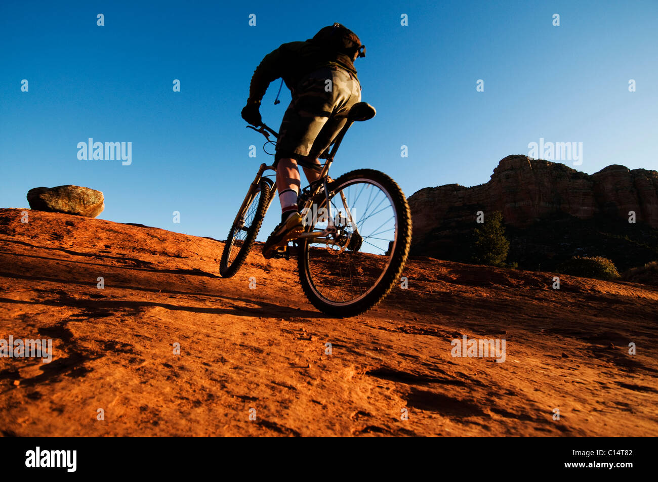 Un homme d'âge moyen chevauche son vtt à travers le pays des roches rouges de Sedona, AZ. Banque D'Images
