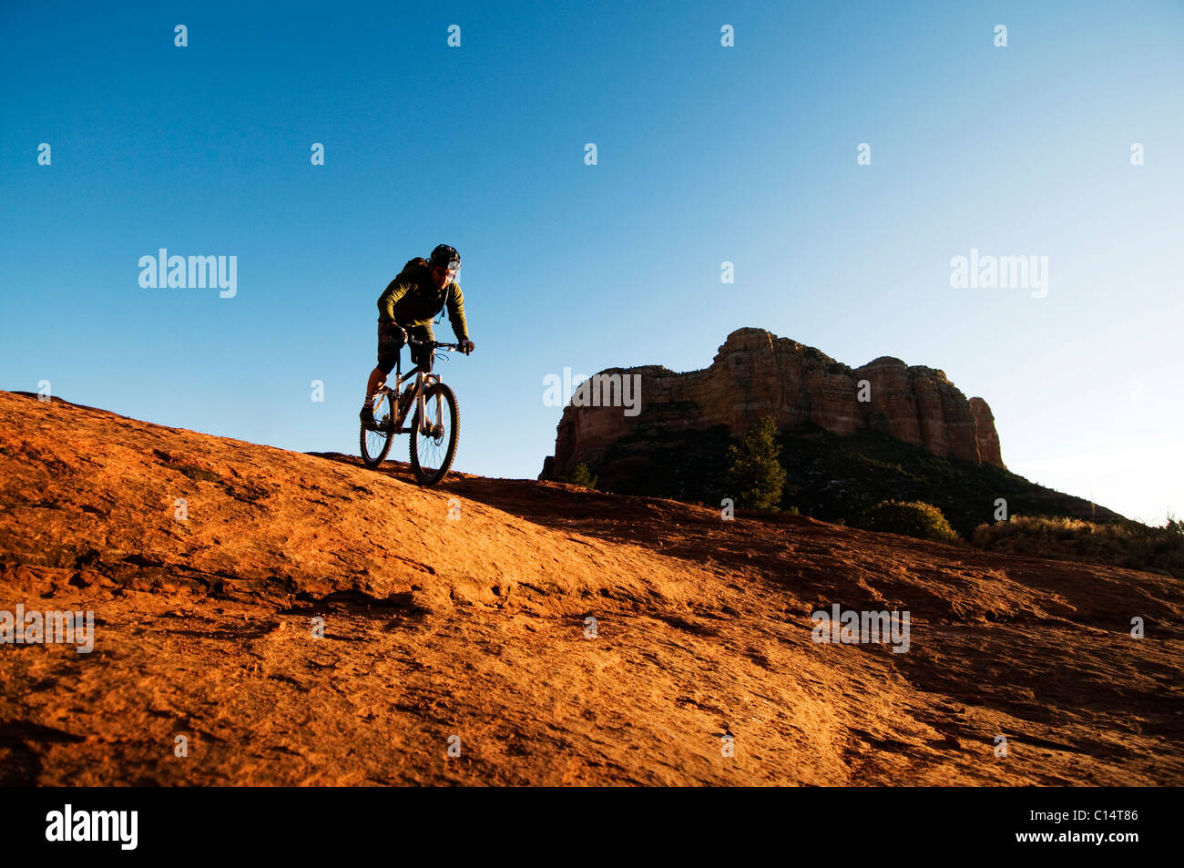 Un homme d'âge moyen chevauche son vélo de montagne à travers le pays des roches rouges de Sedona, AZ. Banque D'Images