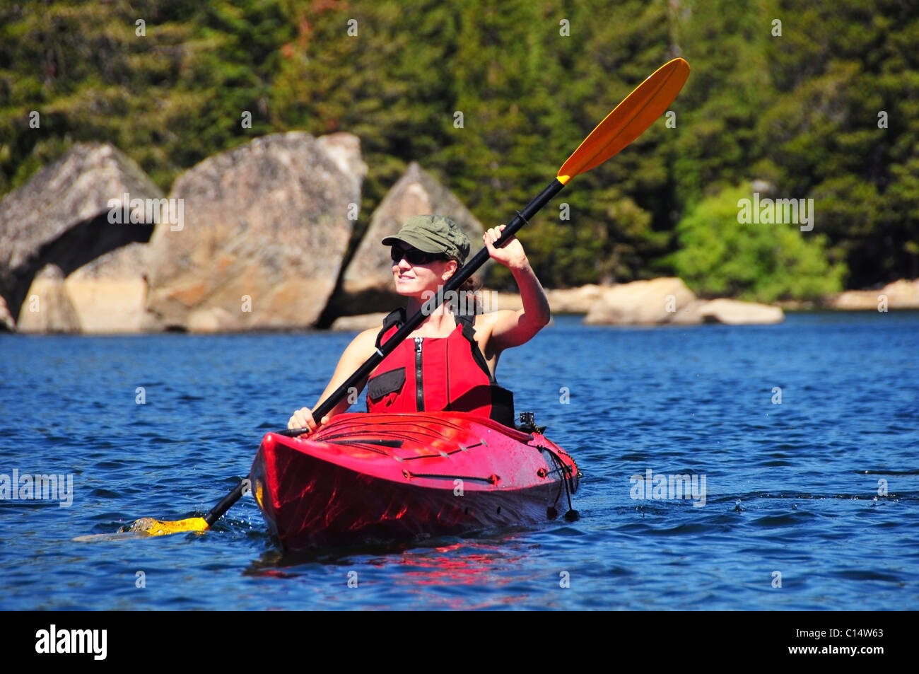 Une femme kayaks sur le lac Caples près de Kirkwood, en Californie à l'été. Banque D'Images