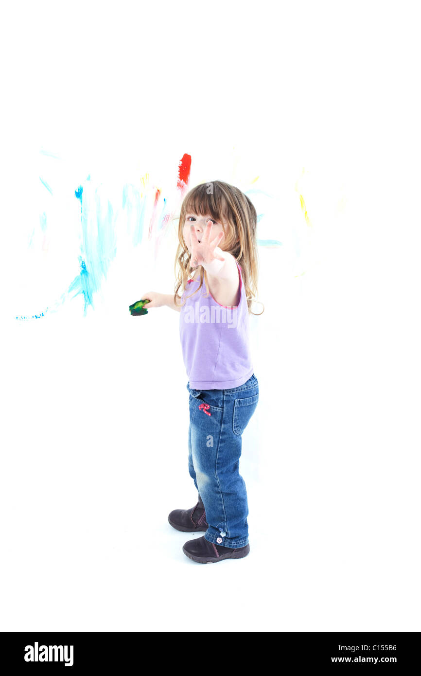 Arty toddler peinture sur mur blanc Banque D'Images