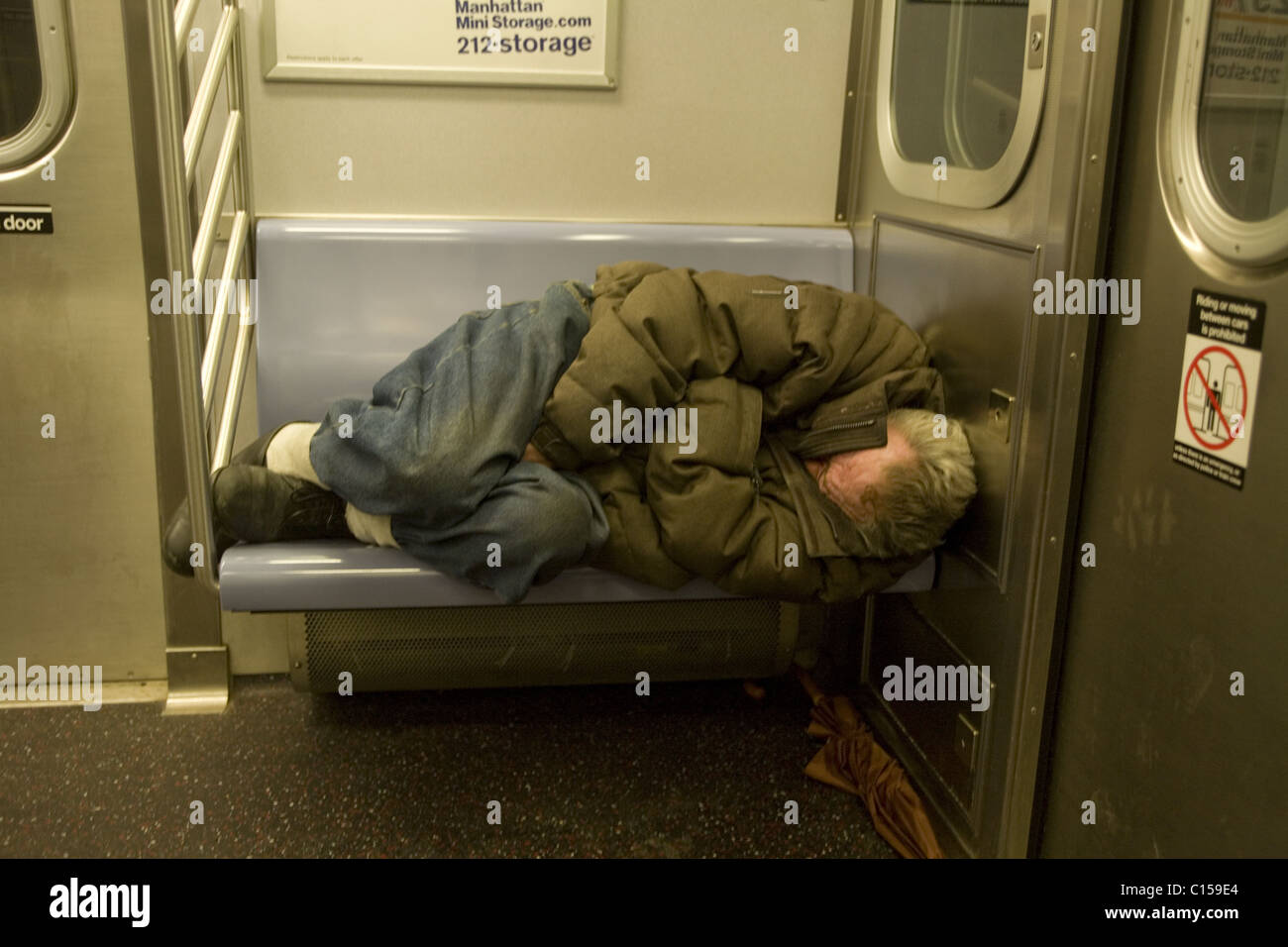 Sans-abri dormir sur un New York City Subway train Banque D'Images