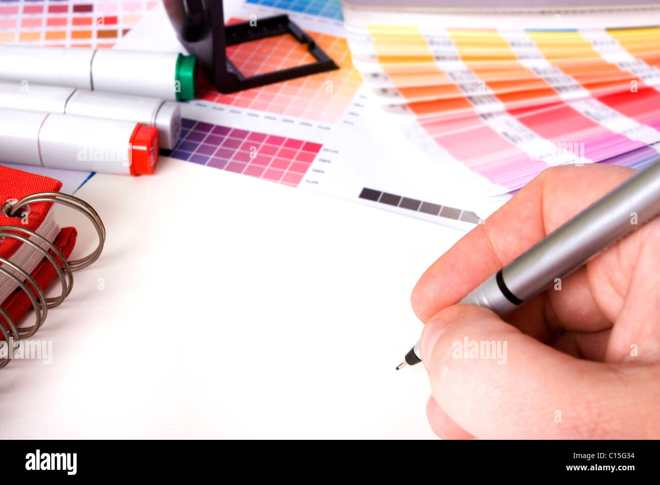 Design designer entouré par des échantillons de couleur et des stylos avec le papier blanc Banque D'Images