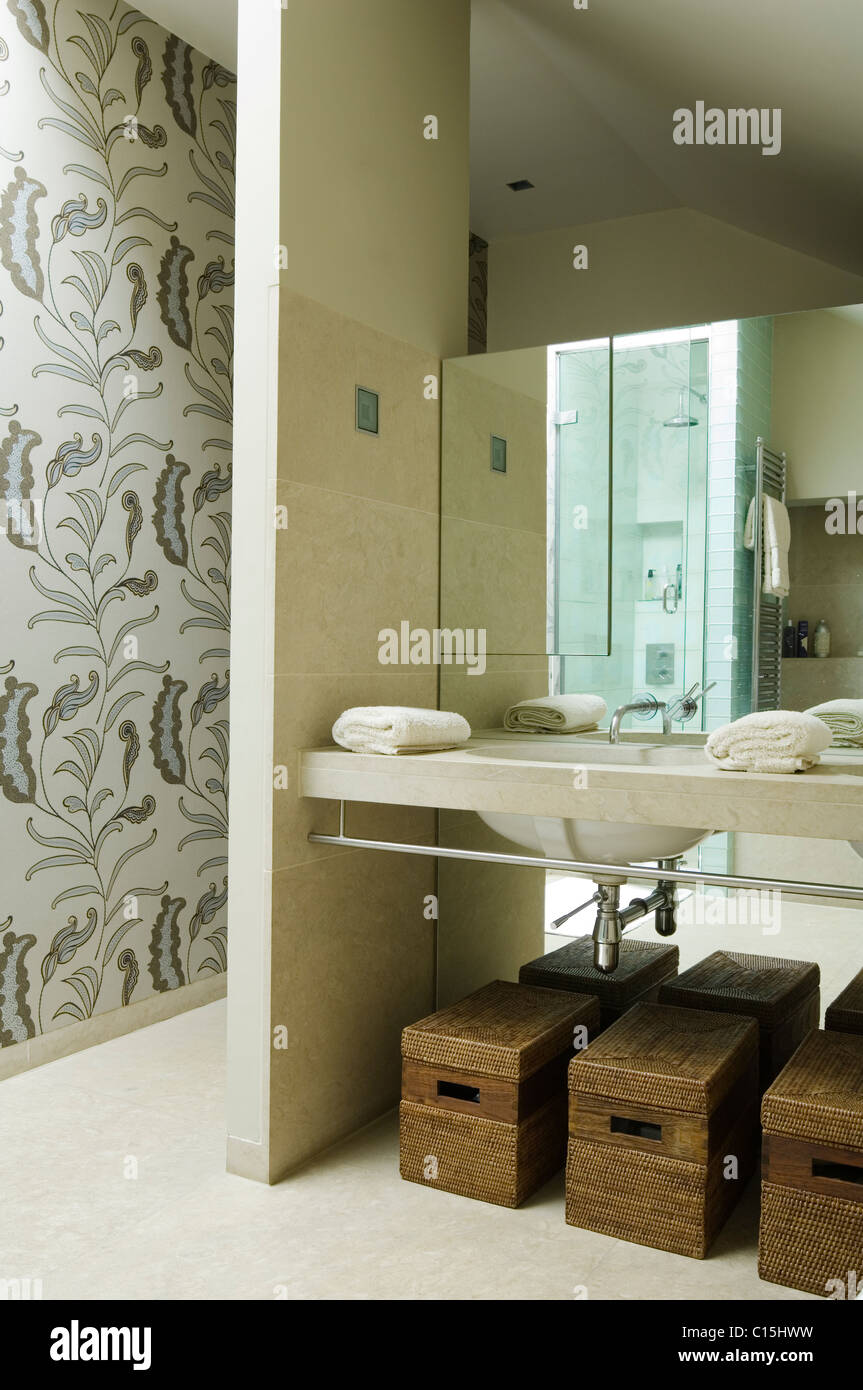 Des paniers de rangement sous lavabo dans une salle de bains privative avec  papier peint à motifs floraux Photo Stock - Alamy