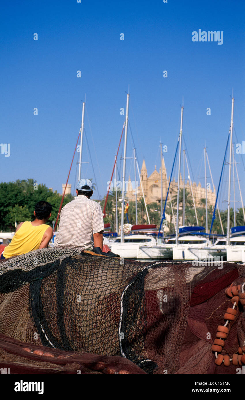 Les pêcheurs assis sur leurs filets dans le port en face de la cathédrale La Seu, Palma de Majorque, Majorque, Iles Baléares Banque D'Images