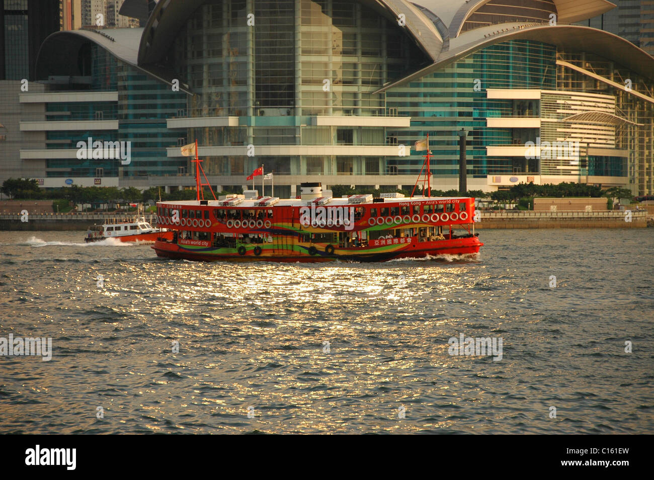 Ferry orange vif en face de Hong Kong Convention Centre au coucher du soleil Banque D'Images