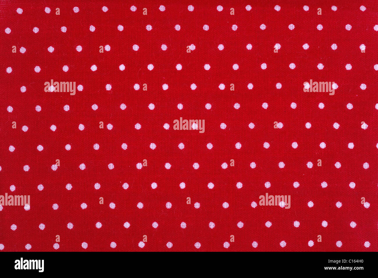Motif tacheté blanc sur un morceau de coton rouge Banque D'Images
