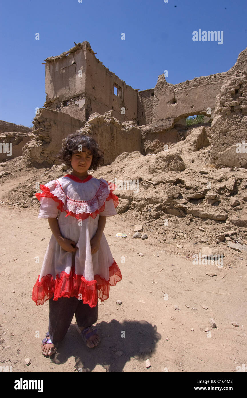 Fille en robe en village bombardé, en Afghanistan Banque D'Images