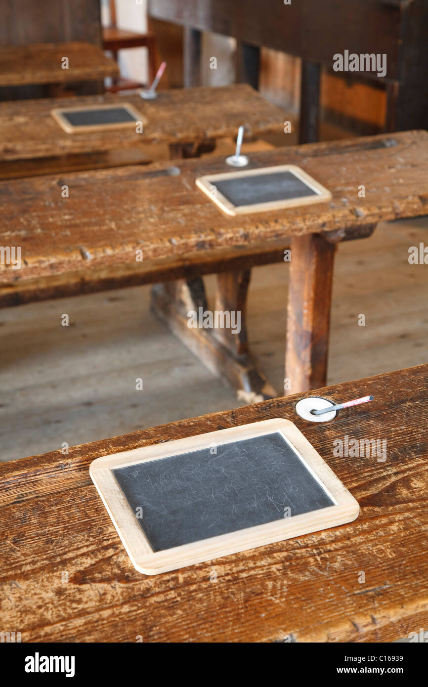 L'ancienne salle de classe avec des bancs en bois et ardoise tablets Banque D'Images