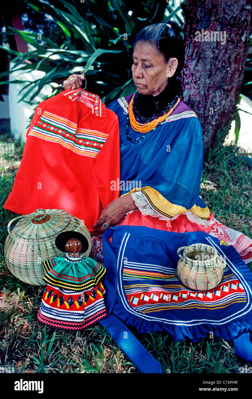 Une vieille femme indienne Miccosukee affiche des vêtements traditionnels et de l'artisanat à son Seminole village tribal dans les Everglades en Floride, USA. Banque D'Images