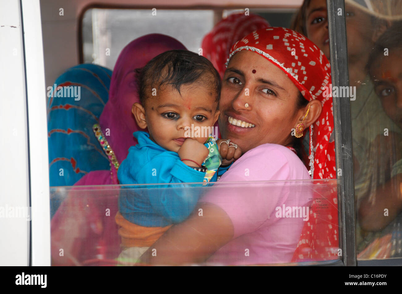 Femme indienne tenant un enfant dans une voiture entièrement occupé, près de Jodhpur, Rajasthan, Inde du Nord, l'Asie Banque D'Images