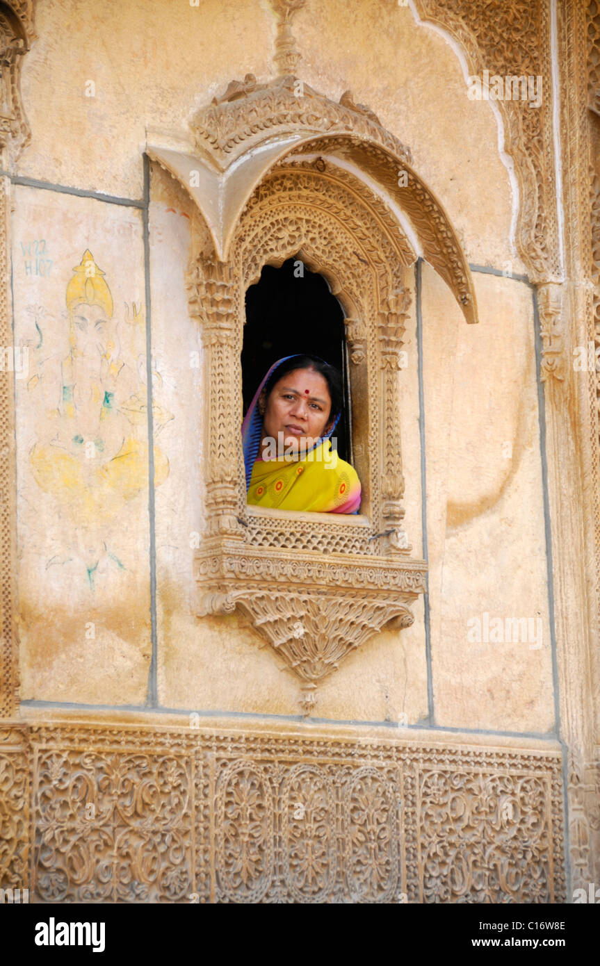 Stonemason's art, femme portant un sari indien assis à une fenêtre dans Fort de Jaisalmer, Rajasthan, Inde du Nord, l'Asie Banque D'Images