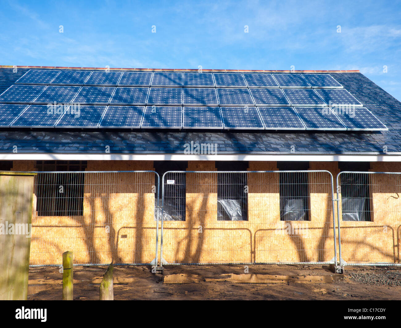 Des panneaux solaires photovoltaïques sur le toit de l'extension d'un espace boisé visitors center en construction au printemps 2011 Banque D'Images