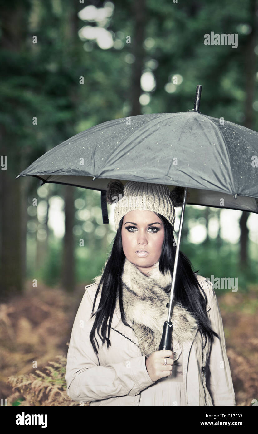Shot de Attrractive Teen en forêt sous la pluie - avec parapluie Banque D'Images