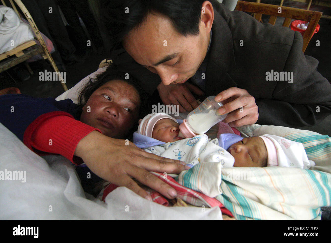 Chirurgiens pour séparer les jumeaux siamois deux jumeaux siamois sont tendrement nourris par leurs parents aimants, quelques jours avant une délicate Banque D'Images