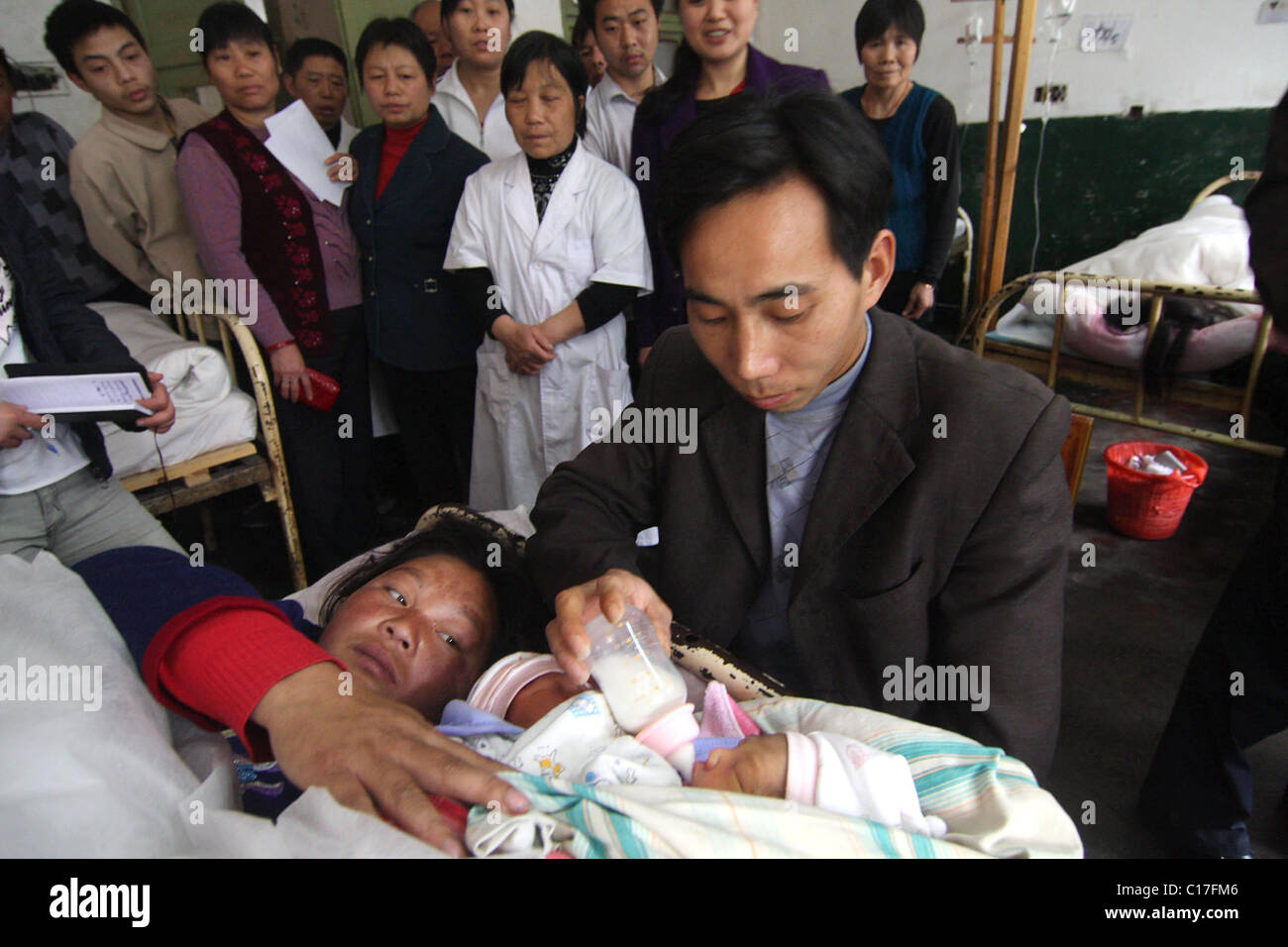Chirurgiens pour séparer les jumeaux siamois deux jumeaux siamois sont tendrement nourris par leurs parents aimants, quelques jours avant une délicate Banque D'Images