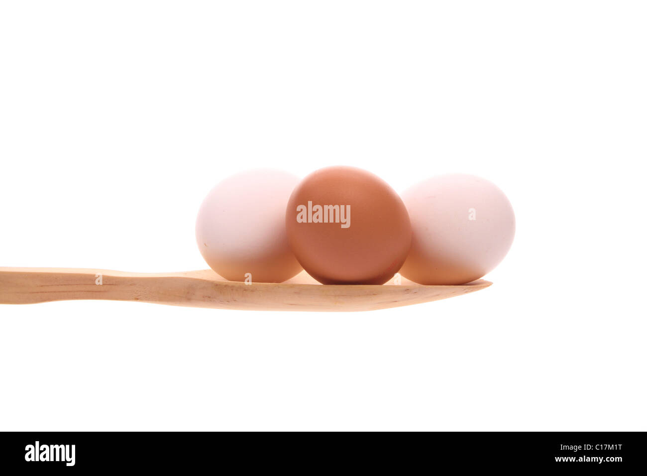Oeufs simplement offert sur une cuillère en bois isolé sur fond blanc Banque D'Images