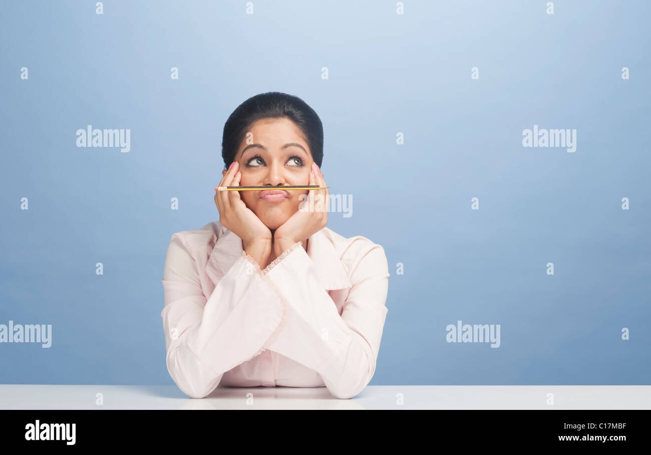 L'équilibrage de femme crayon sur sa lèvre Banque D'Images