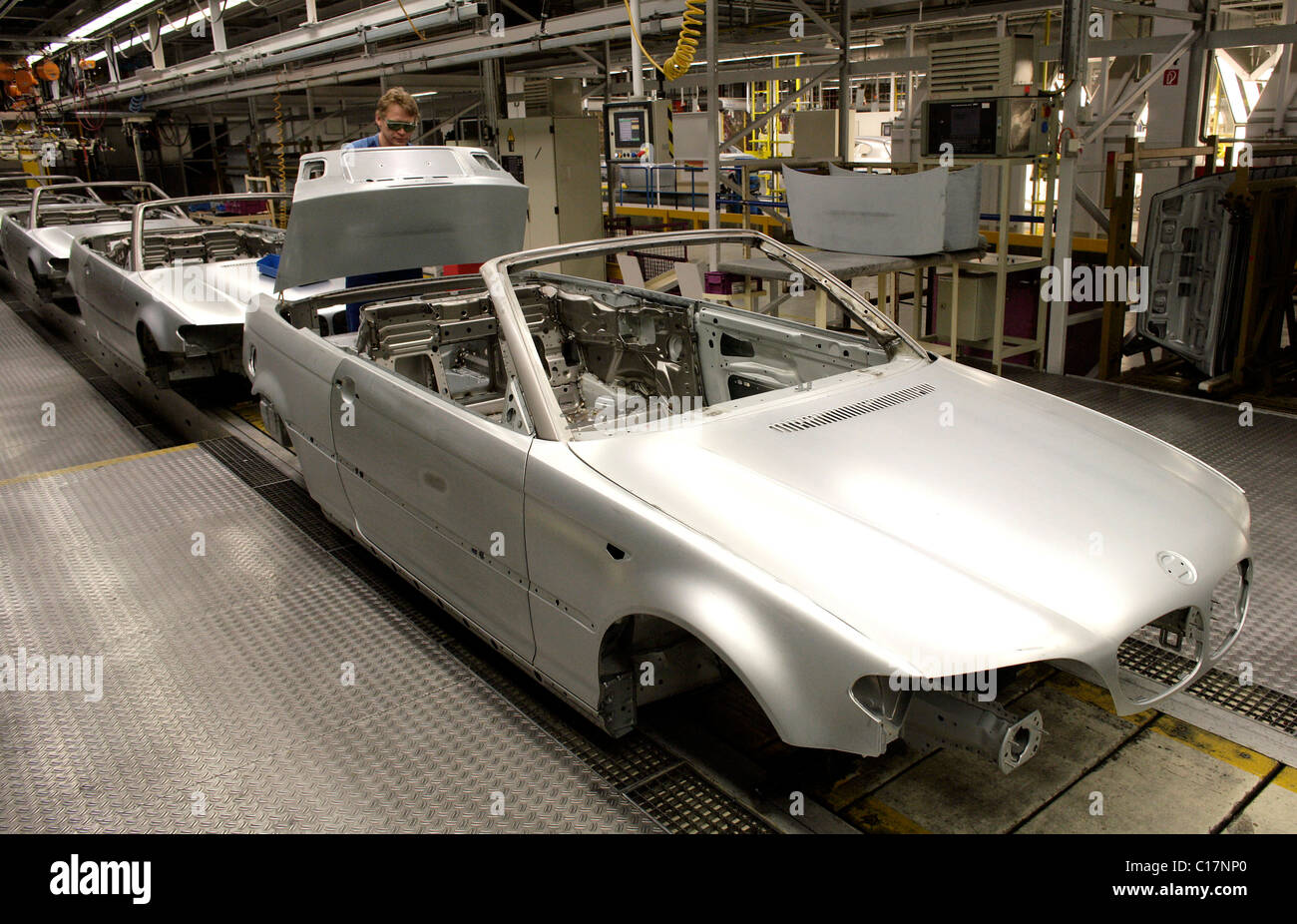 Un travailleur d'usine de l'assemblage du coffre d'une BMW Série 3 Cabriolet sur le châssis à l'usine d'assemblage à l'usine de BMW AG Banque D'Images