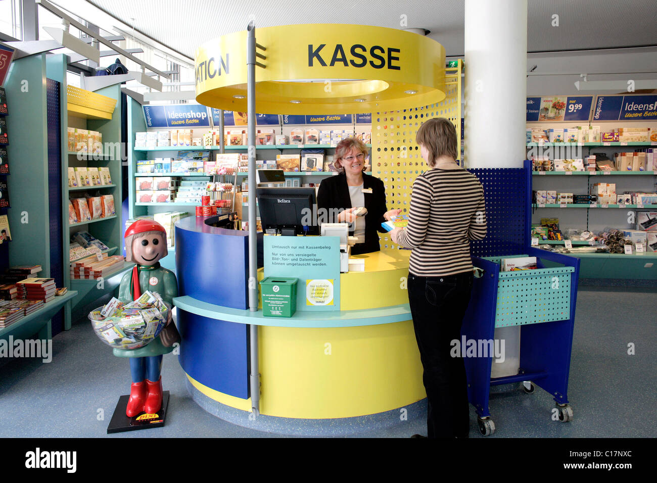 Client de payer pour un livre à la caisse dans un magasin Plus Weltbild, Groupe d'édition Weltbild, Augsbourg, Bavière Banque D'Images