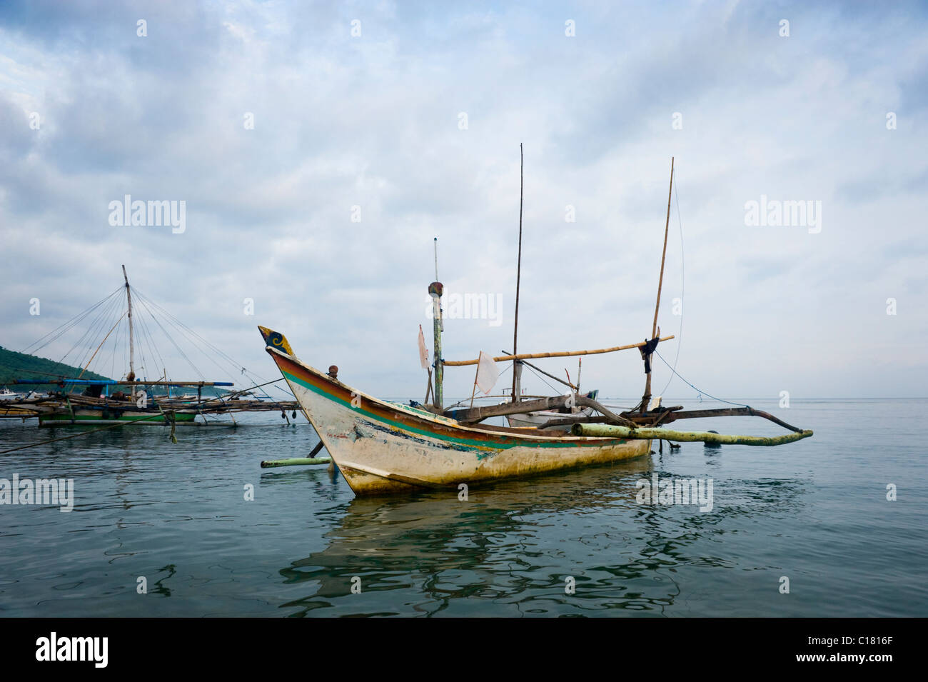 À l'aube dans le village de Pemuteran, Bali, bateaux de pêche traditionnels appelés jukung sont à l'ancre en attente de sortir pour la journée. Banque D'Images
