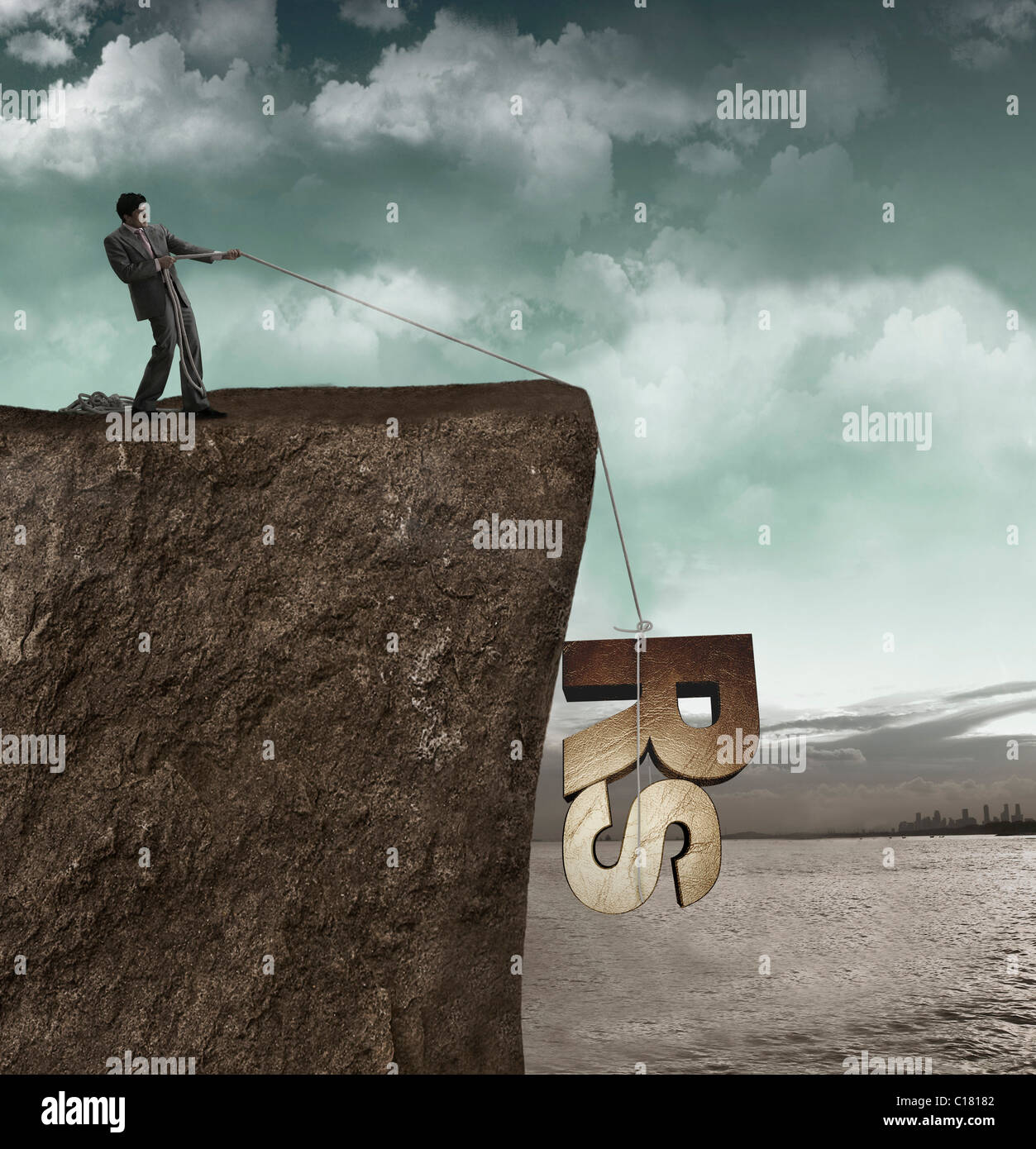Businessman pulling un rupee symbole à partir d'une falaise Banque D'Images