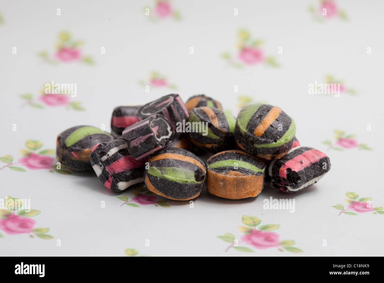 Les sucreries et les satins réglisse bonbon sur un papier fond photographié dans un studio Banque D'Images