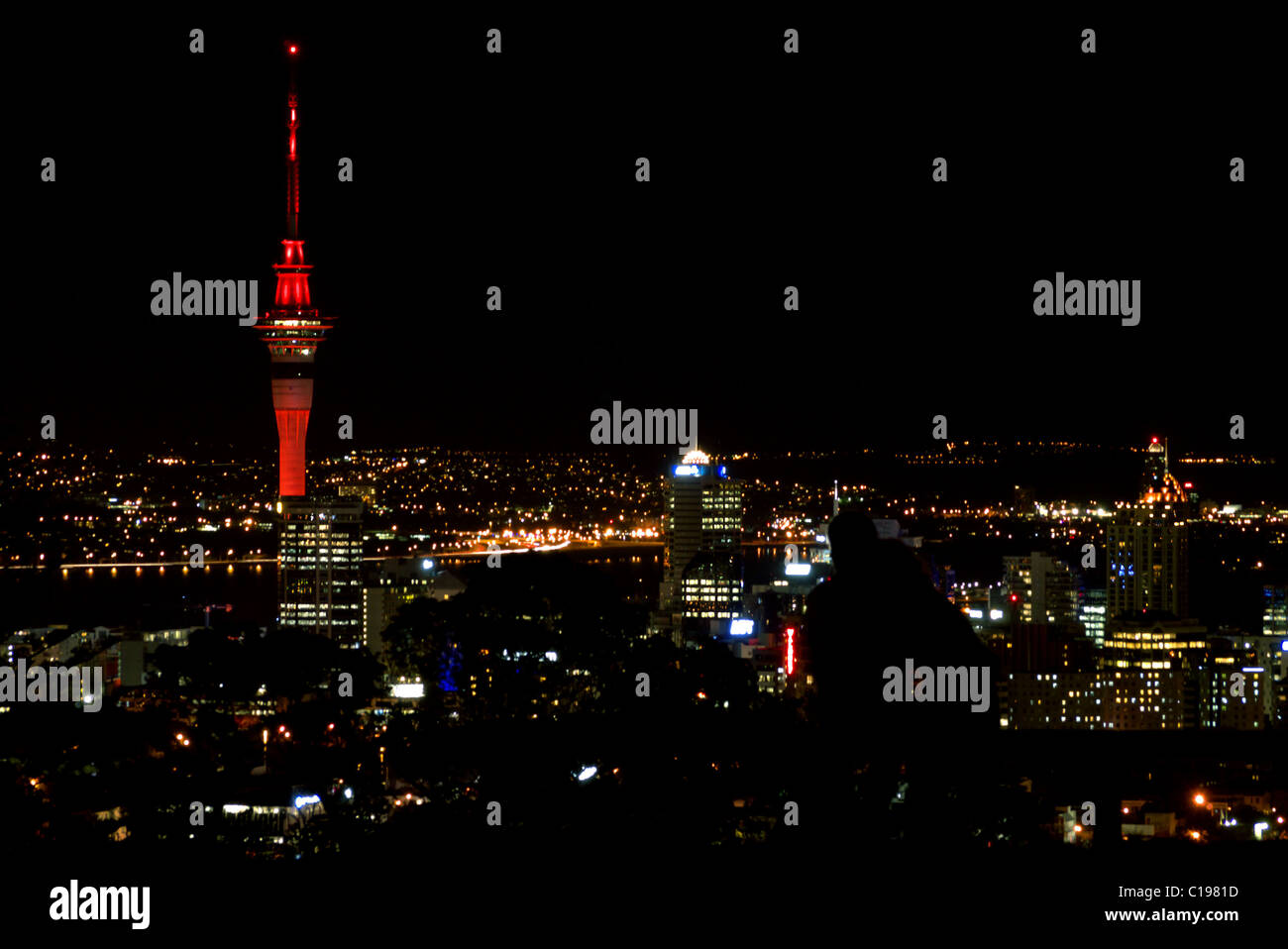 Un couple embrasser tout en regardant les toits de la ville de Auckland au sommet du Mont Eden, le plus haut point naturel à Auckland. Banque D'Images