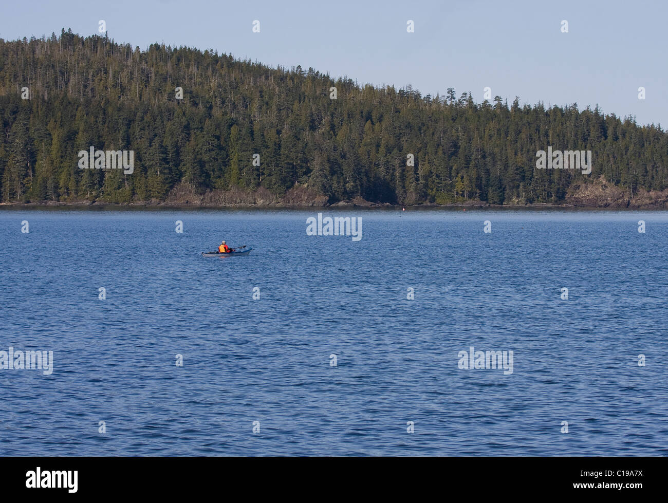 Le kayakiste en mer au large de solitaire stories plage Port Hardy l'île de Vancouver avec la forêt en arrière-plan Banque D'Images