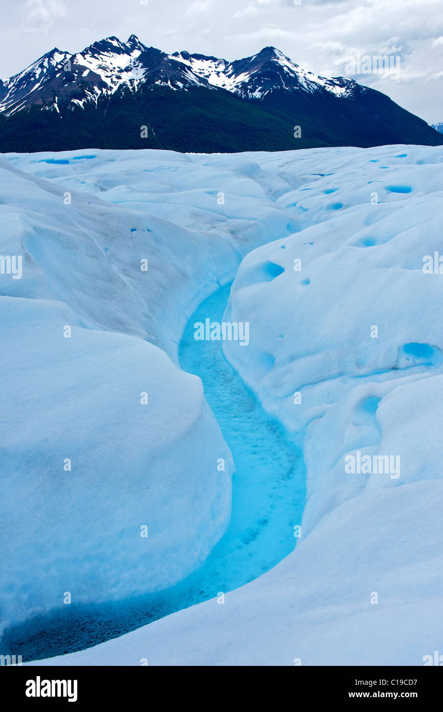 Un ruisseau sur bleu glacier avec vue sur la montagne en ce qui concerne la vue. Banque D'Images