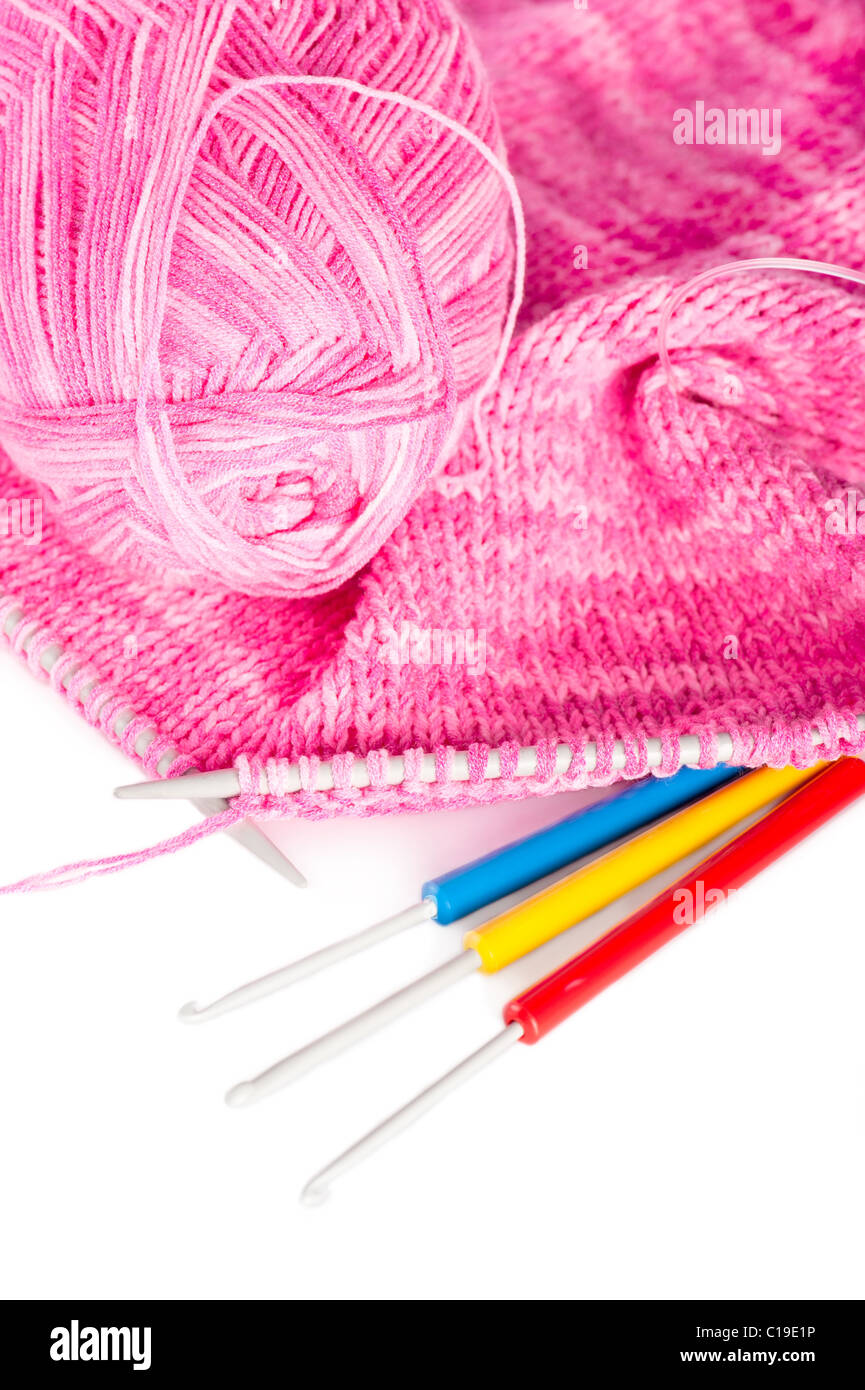 L'aiguille à la main, toile rose en tricot laine à tricoter et à crochets Banque D'Images