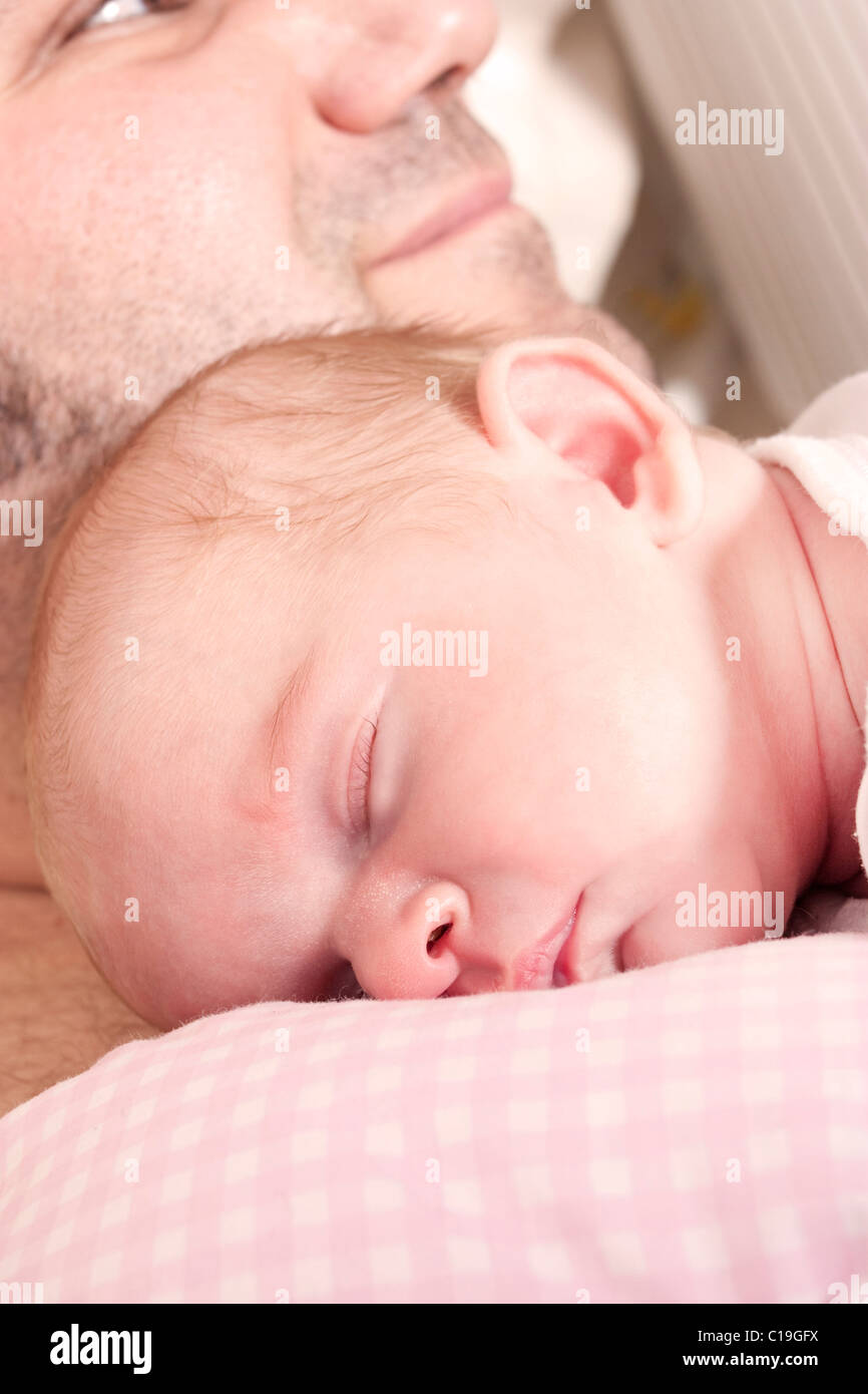 Un père berceaux sommeil sa Naissance bebe Fille Banque D'Images
