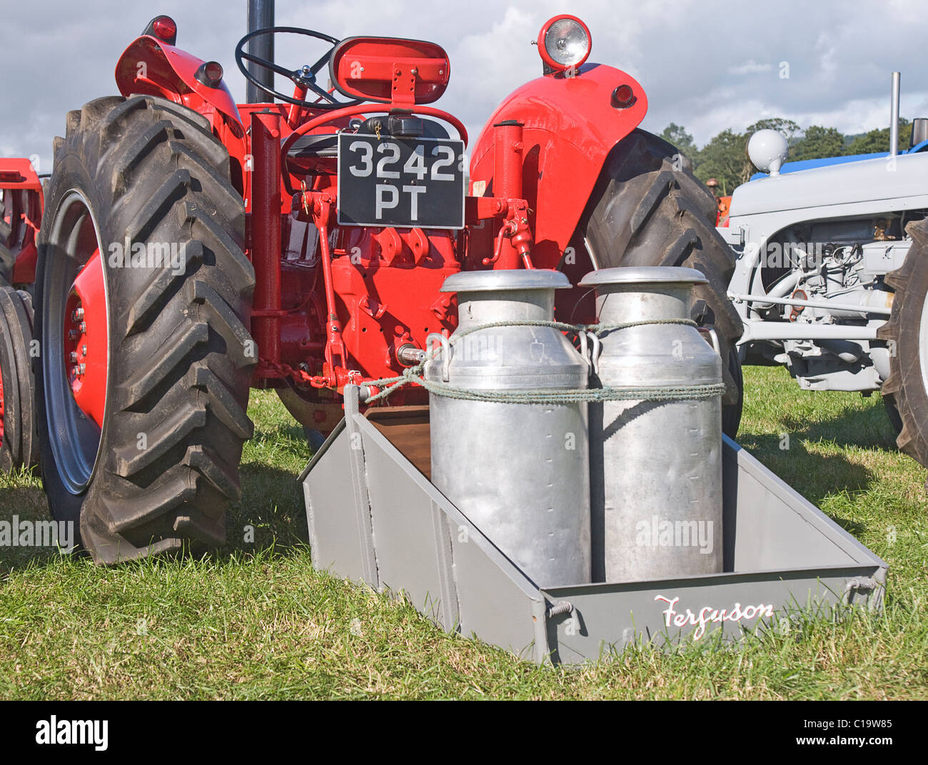 Vieux bidons de lait sur le dos d'un vieux tracteur Ferguson. Photographié à Hunton juste à vapeur, Yorkshire du Nord. Banque D'Images