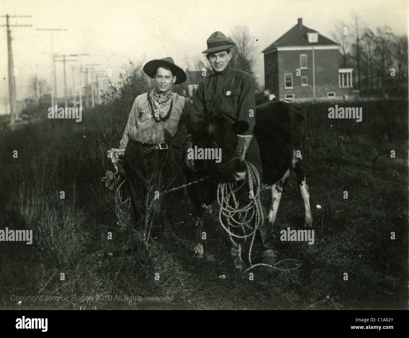 Les cavaliers habillés comme des cow-boys à l'extérieur chambre en 1910 michigan de poteaux télégraphiques whips Banque D'Images