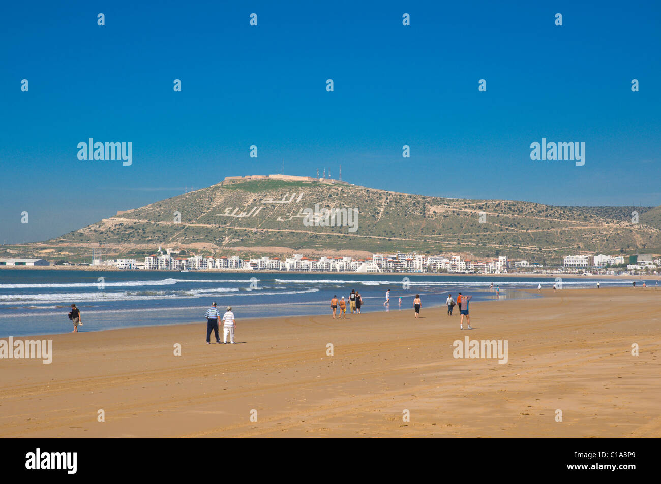 Les gens qui marchent sur la plage avec en arrière-plan la Kasbah Agadir Souss sud Maroc Sud Banque D'Images