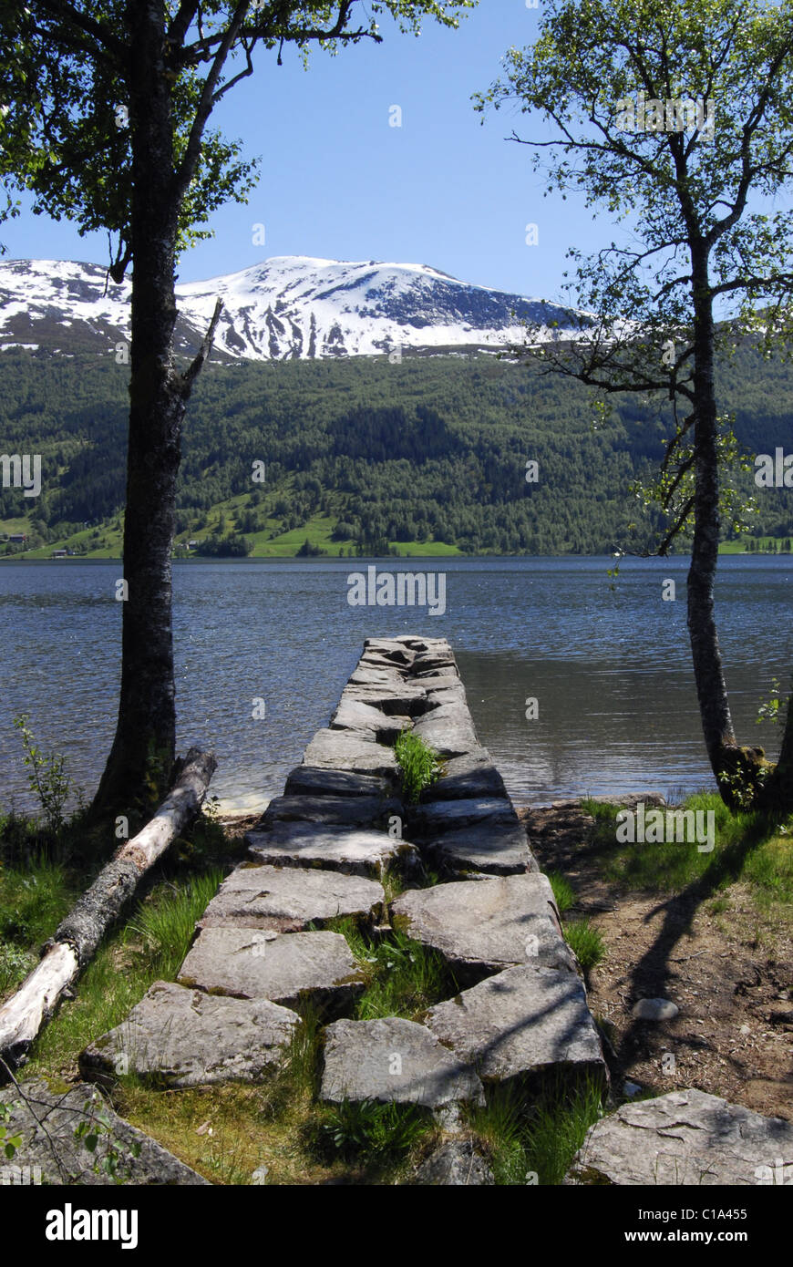 Jetée de pierre Jølstravatnet, comté de Sogn og Fjordane, en Norvège, avec lac et montagnes en arrière-plan Banque D'Images
