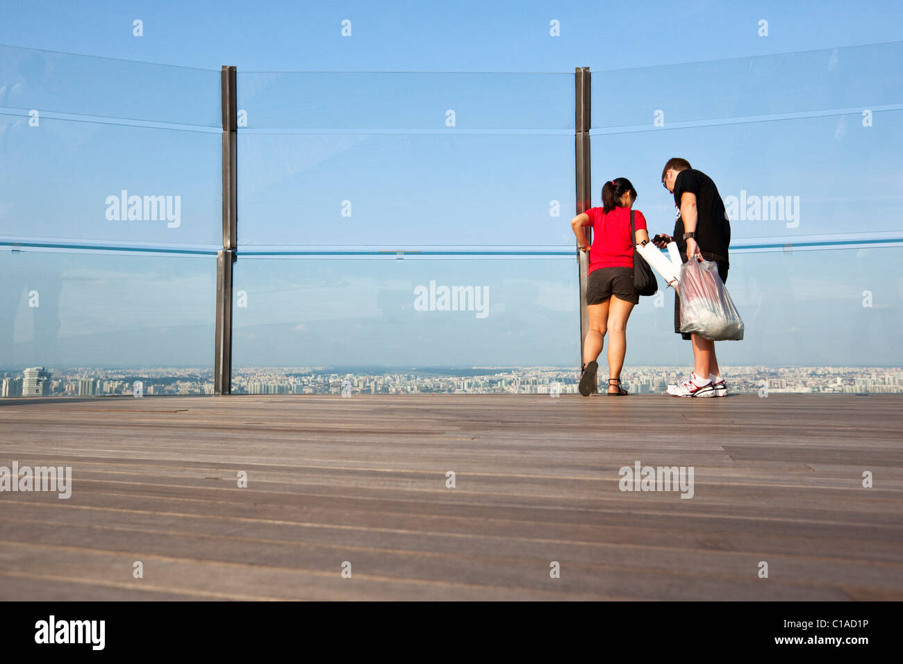 Couple looking out sur Singapour à partir de la plate-forme d'observation de la Marina Bay Sands SkyPark. Marina Bay, Singapour Banque D'Images