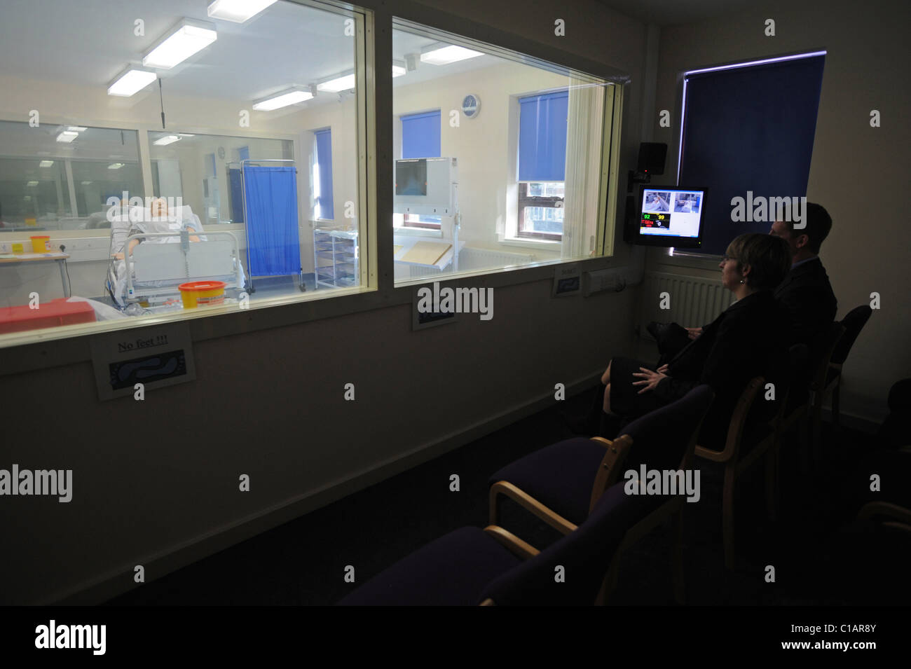 Les élèves regarder SimMan 3G un nouveau patient factice à partir de la zone d'observation de la salle de simulation à l'hôpital Worthing Banque D'Images