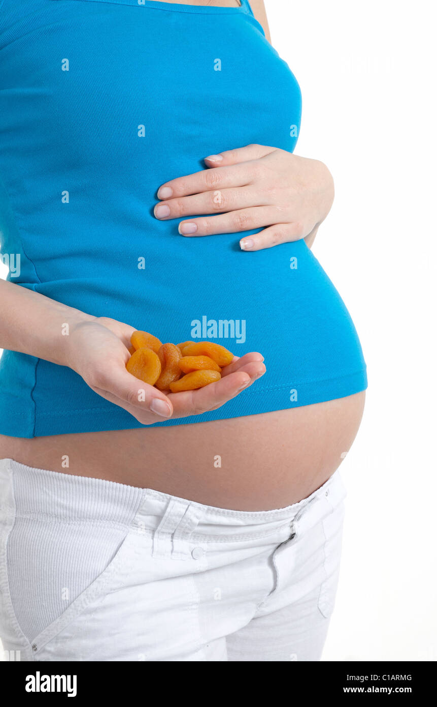 Pregnant woman holding abricots séchés Banque D'Images