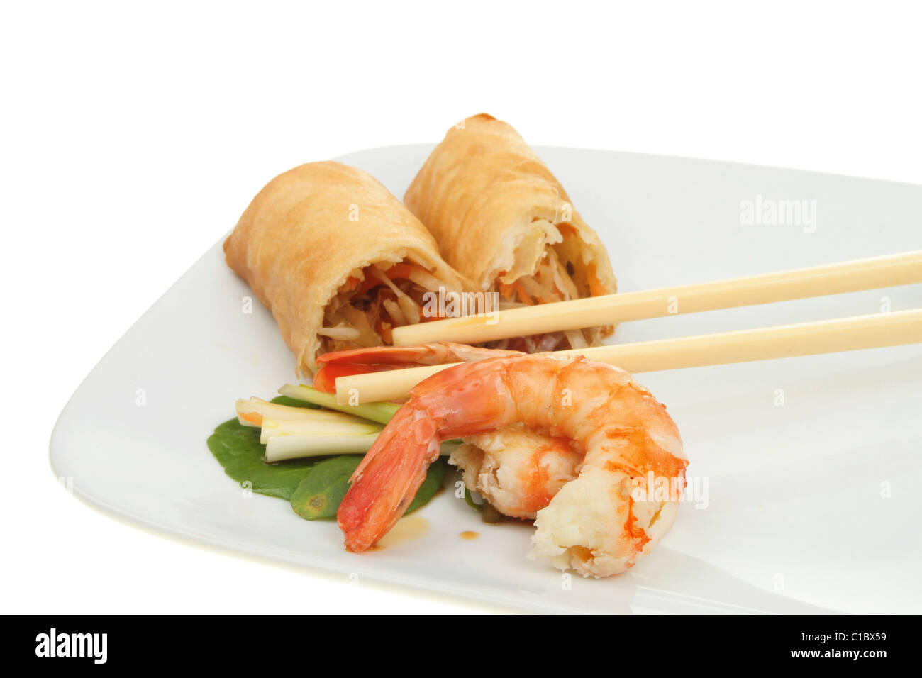 Crêpes aux crevettes et au rouleau chinois avec des baguettes sur une plaque Banque D'Images