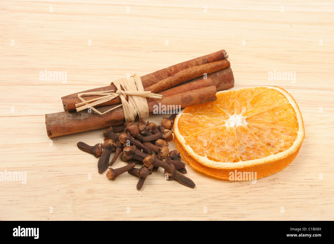 La cannelle, girofle et d'orange séchée sur une planche en bois Banque D'Images