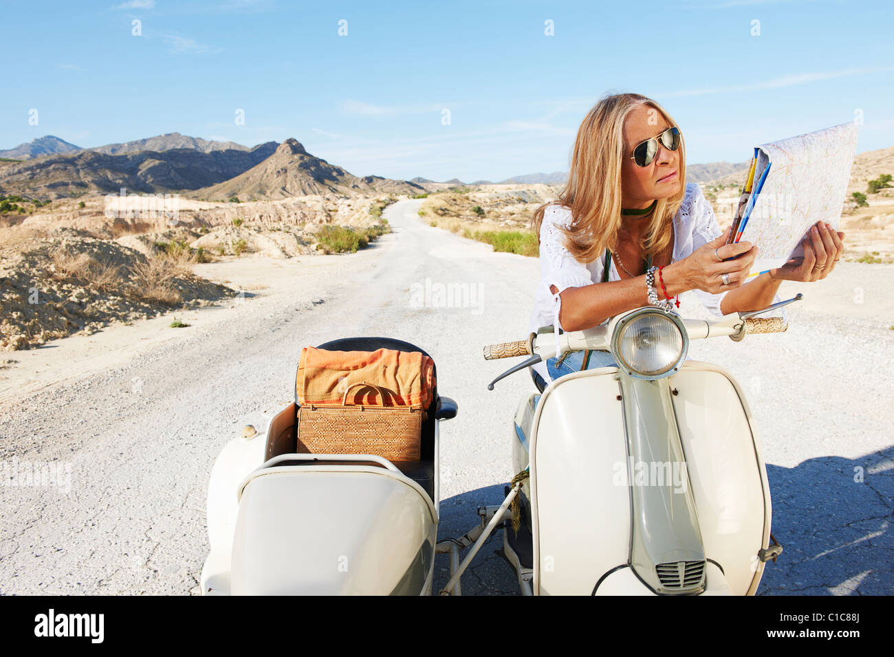 Femme assise sur moto avec la carte Banque D'Images