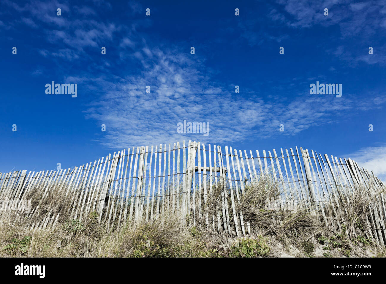 Clôture en bois sur dune de sable avec ciel bleu Banque D'Images